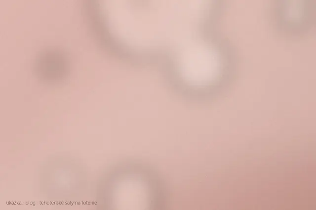 Dlhé splývavé tehotenské šaty visia pri okne ateliéru